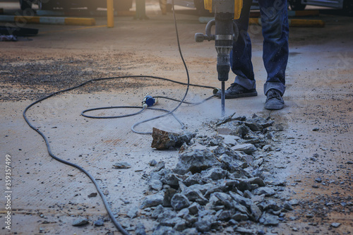 фотографія Worker drilling cement concrete with jackhammer machine at outdoor construction