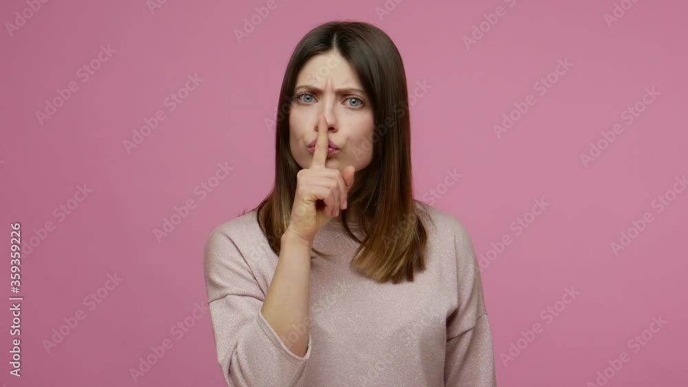 Shh, be quiet! Worried brunette young woman shushing, asking to keep silence and don't tell secret information, holding finger on lips to keep mystery. indoor studio shot isolated on pink background Shh, be quiet! Worried brunette young woman shushing, asking to keep silence and don't tell secret information, holding finger on lips to keep mystery. indoor studio shot isolated on pink background