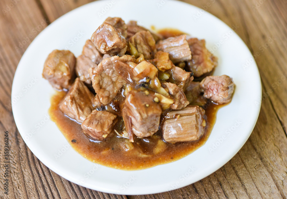 beef cuts and cooked food on white plate - meat beef cube roast bbq with sauce and spices garlic beef cuts and cooked food on white plate - meat beef cube roast bbq with sauce and spices garlic