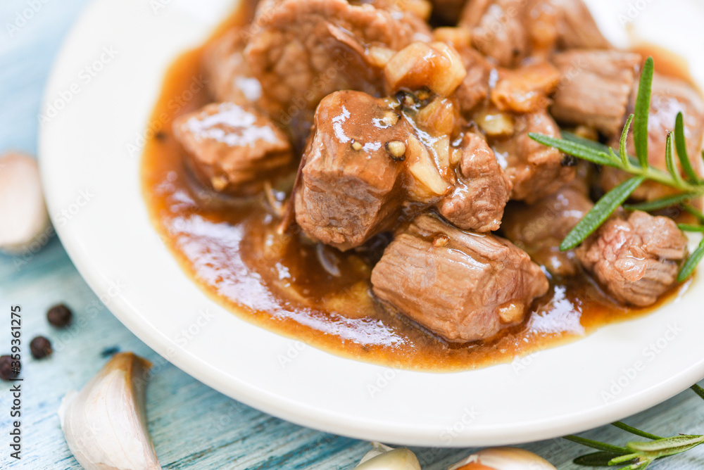 beef cuts and cooked food on white plate - meat beef cube roast bbq with sauce and spices garlic beef cuts and cooked food on white plate - meat beef cube roast bbq with sauce and spices garlic