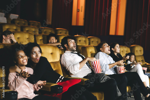 Caucasian men watching cinema in theater and surpise expression face