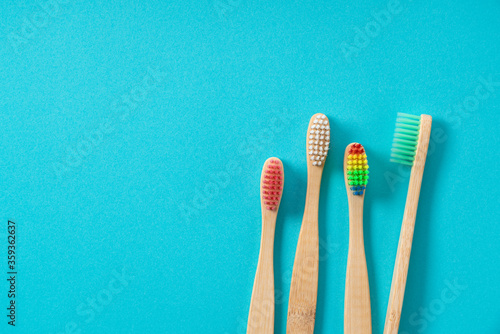 Bamboo toothbrushes in various patterns on a blue background.