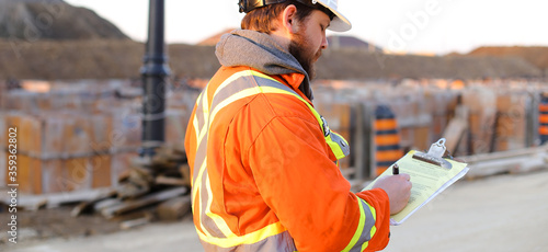 Εκτύπωση καμβά Banner of inspector in orange workwear with blueprints on construction site