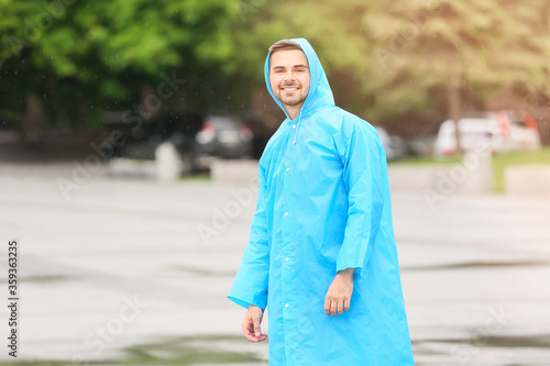 Young man wearing raincoat outdoors © Pixel-Shot