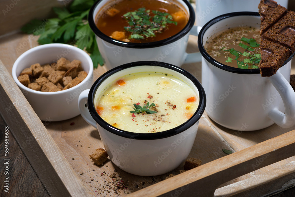 hot soups in mugs on wooden tray