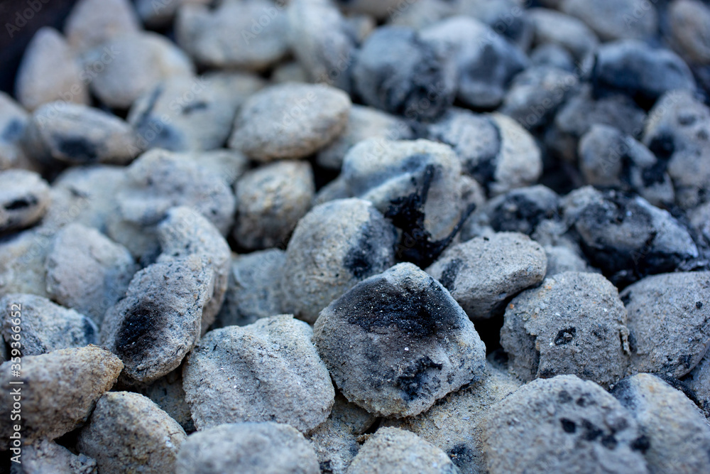 A closeup view of an barbecue area filled with used gray charcoal. A closeup view of an barbecue area filled with used gray charcoal.