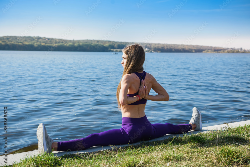 Beautiful woman doing split on a warm summer day. sport active lifestyle concept