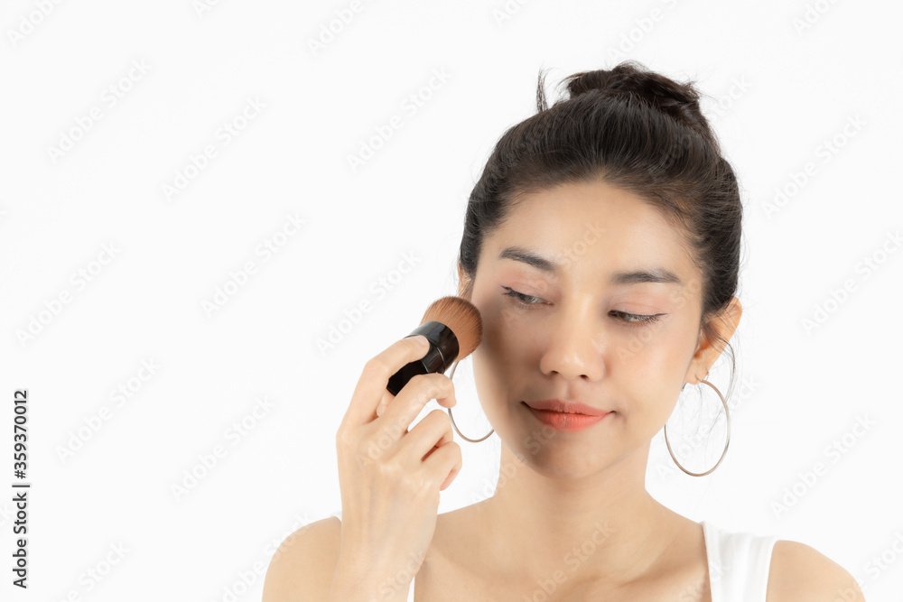 Healthy and cosmetics concept. Beauty face of young Asian woman applying make up with brush over white isolated background. Healthy and cosmetics concept. Beauty face of young Asian woman applying make up with brush over white isolated background.