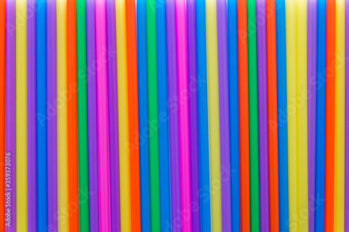 A solid background of many plastic colored straws arranged in row