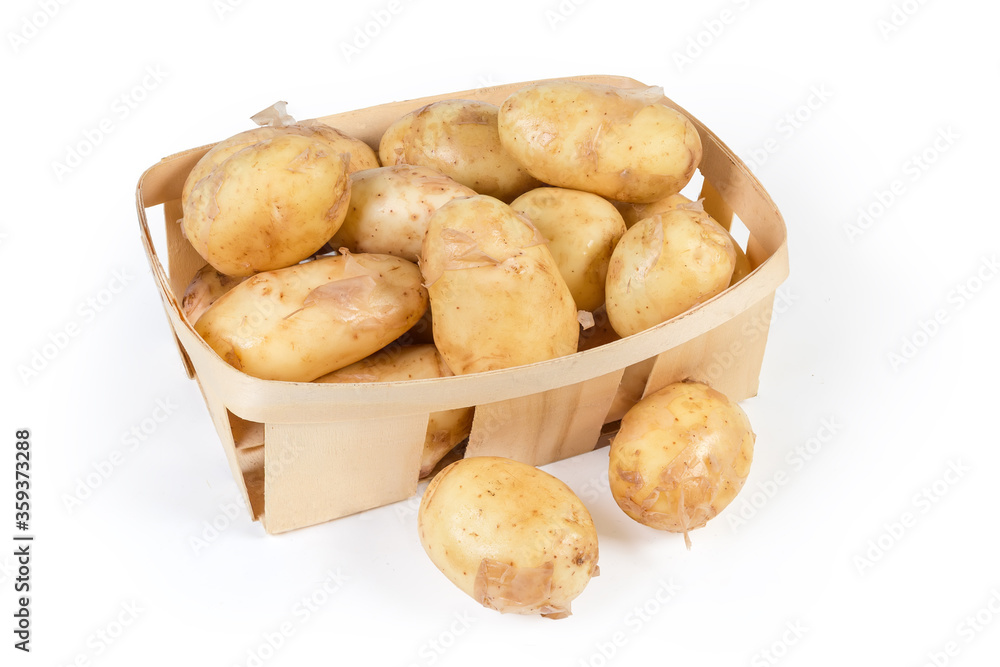 Raw yellow young potatoes with skin in small wooden basket Raw yellow young potatoes with skin in small wooden basket