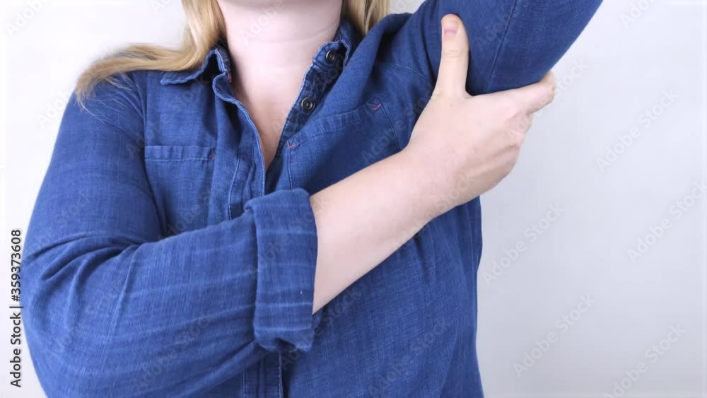 A woman suffers from pain in the armpit. Sweating, unpleasant odor