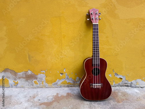ukulele with yellow background.