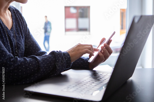 businesswoman working on tablet computer anc checking her phone 