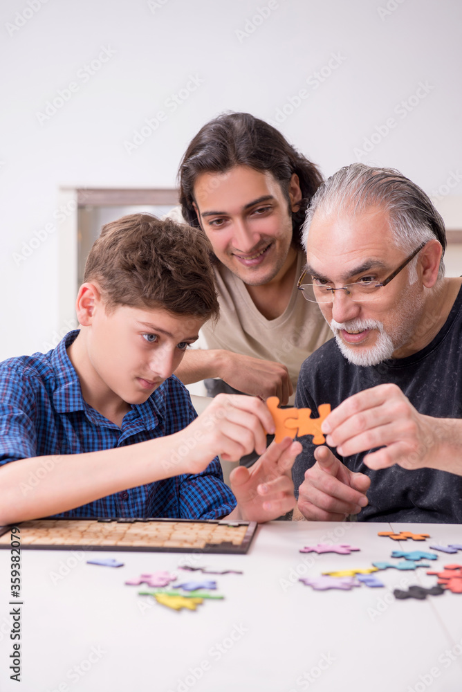 Three generations of family playing jigsaw puzzle game Three generations of family playing jigsaw puzzle game