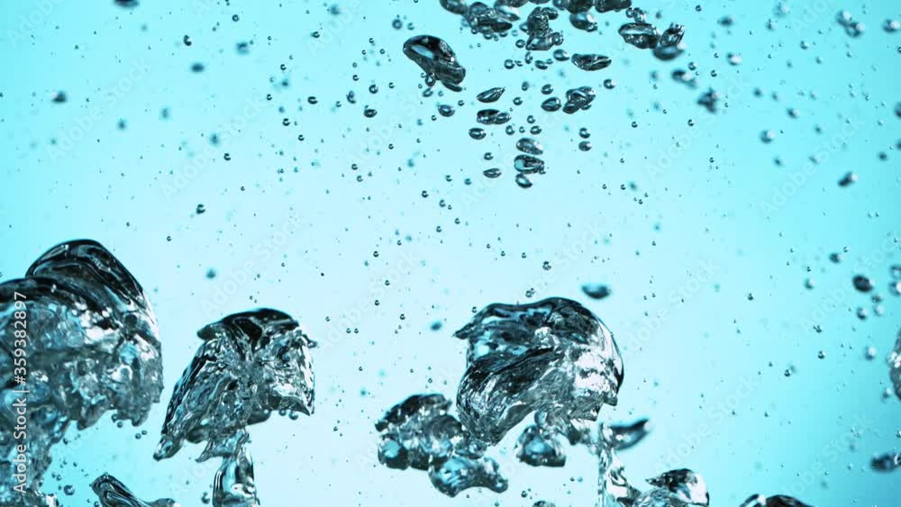 Macro shot of various air bubbles in water rising up on light blue ...