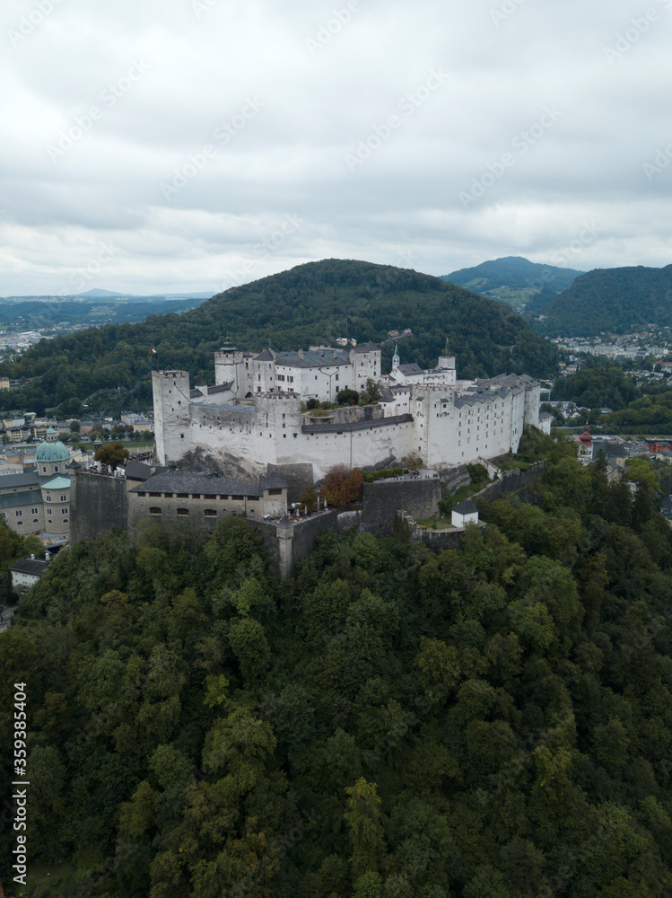 Aerial view of Salzburg castle on the hill, mountain. Hohensalzburg Fortress Panoramic view of city and salzach river from drone. Historic landmarks. Austria, Europe.
