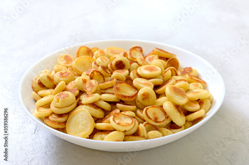 Pancake cereal in a bowl on a light background. Tasty and trendy breakfast. Organic Dutch Mini-Pancakes. Foods trend