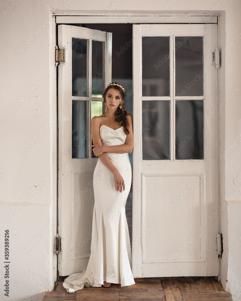 Bride in a wedding dress is standing by the window, romantic atmosphere of the bride's morning Bride in a wedding dress is standing by the window, romantic atmosphere of the bride's morning