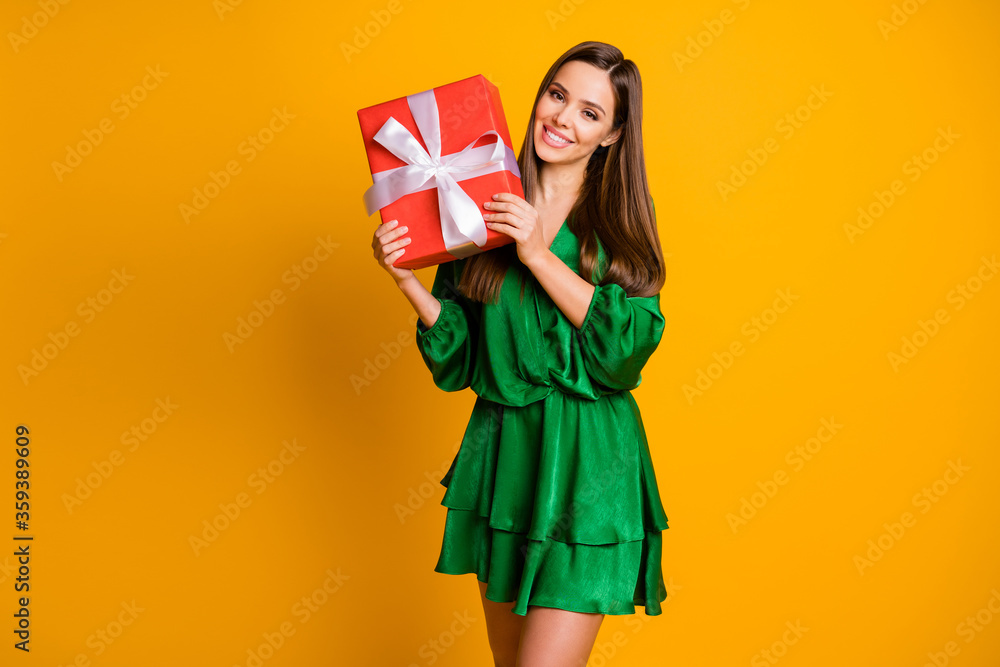 Portrait of her she nice-looking attractive lovely feminine cheerful cheery straight-haired girl holding in hand gift isolated over bright vivid shine vibrant yellow color background Portrait of her she nice-looking attractive lovely feminine cheerful cheery straight-haired girl holding in hand gift isolated over bright vivid shine vibrant yellow color background