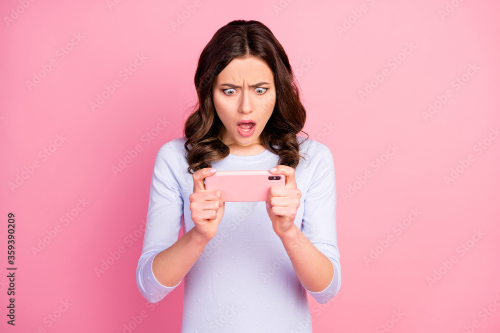 Photo of beautiful lady hold telephone hands stay home quarantine time playing online video game bad mood internet disconnection wear casual white shirt isolated pastel pink color background Photo of beautiful lady hold telephone hands stay home quarantine time playing online video game bad mood internet disconnection wear casual white shirt isolated pastel pink color background
