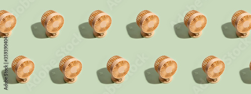 Minimal summer background of mini fan pattern on green background. Isometric trendy style with shadows