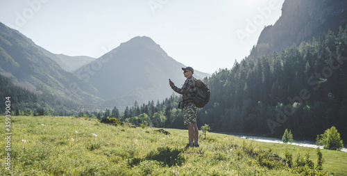 hiker men with phone in the mountains