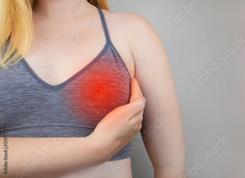 A woman suffers from chest pain. On examination by a gynecologist-mammologist. The concept of the prevention of breast diseases, cancer, mastopathy or hormonal disorders photo