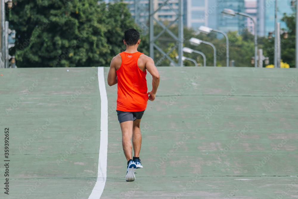 runner on the street be running for exercise on city road; sport, people, exercising and lifestyle concept runner on the street be running for exercise on city road; sport, people, exercising and lifestyle concept