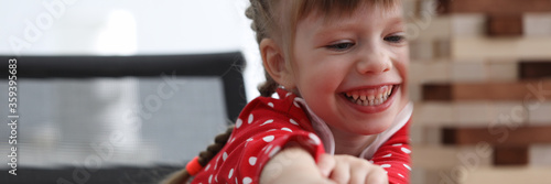 Quadro em tela Girl child sit table and laughs while playing game
