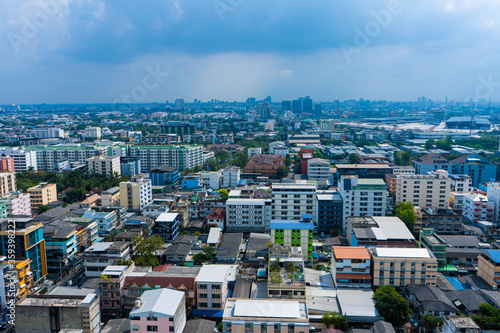 View from the high floor of the streets of Bangkok. Tall buildings and roofs of small houses. City landscape
