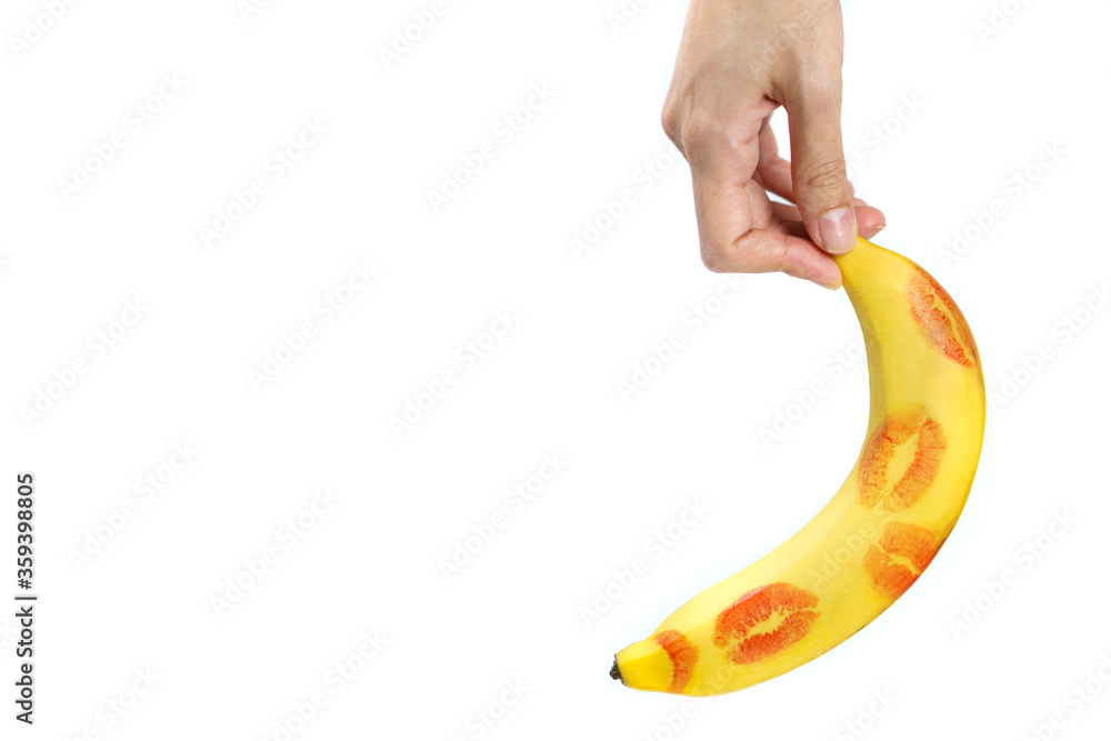 Banana with red lipstick marks with hand on white background. isolated Stock Photo Adobe Stock