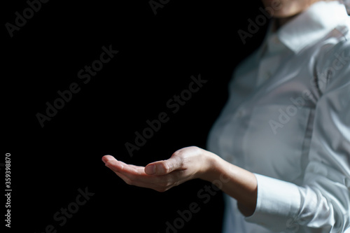Business woman open empty hand on black background.