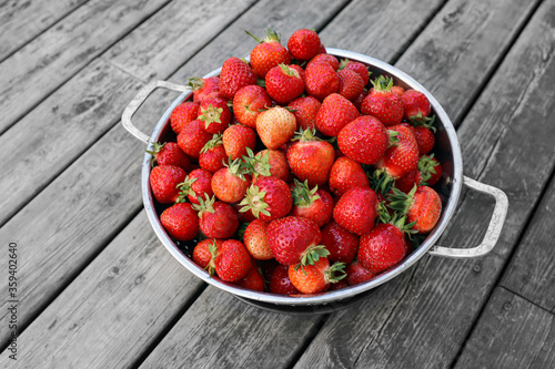 Fresh swedish strawberries during Summer. Bowl standing on an old wooden table. Dessert for Midsummer holiday.