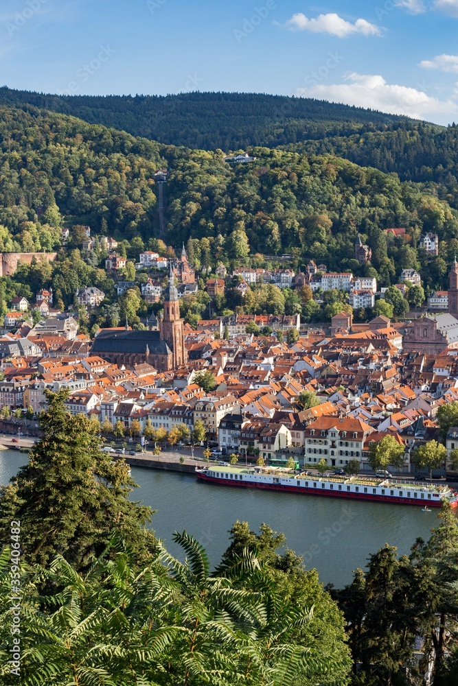 Aerial view of the red tiled roof buildings. Top view of the historic center Heidelberg city in Germany. Cathedral in the center. Town on the river. Blue sky background copy space.