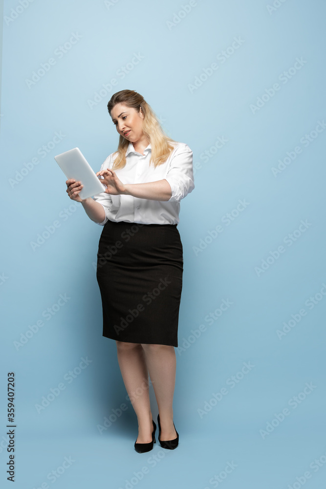 Serious. Young woman in office attire. Bodypositive female character, feminism, loving herself, beauty concept. Plus size businesswoman on blue background. Boss, beautiful. Inclusion, diversity. Serious. Young woman in office attire. Bodypositive female character, feminism, loving herself, beauty concept. Plus size businesswoman on blue background. Boss, beautiful. Inclusion, diversity.