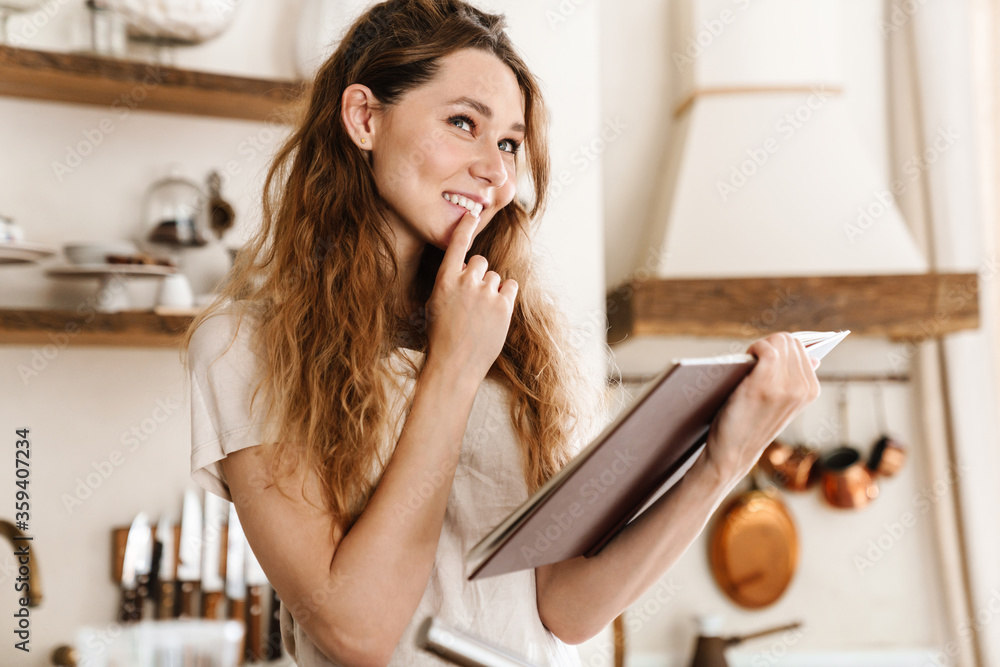 Attractive young cheerful girl baking at the kitchen Attractive young cheerful girl baking at the kitchen