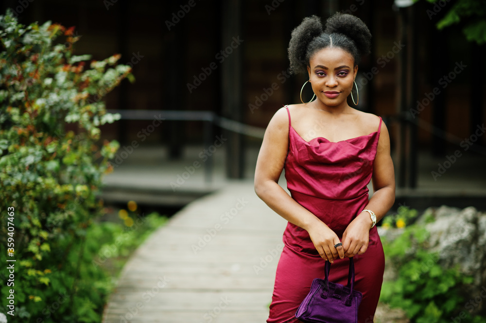 Portrait of a beautiful natural young African woman with afro hair. Black model in red silk dress. Portrait of a beautiful natural young African woman with afro hair. Black model in red silk dress.
