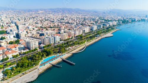 Aerial view of Molos Promenade park on coast of Limassol city centre Cyprus. Bird s eye view of the jetty  beachfront walk path  palm trees  Mediterranean sea  piers  urban skyline and port from above