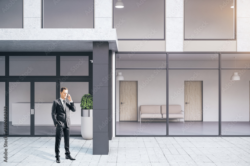 Fototapeta premium Businessman talking near futuristic office building.