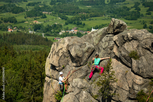 Woman rock climbing near the top with amazing areal view on the surroundings