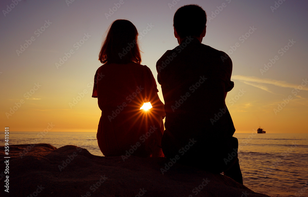 Silhouette of a couple/friends at sunset/sunrise.