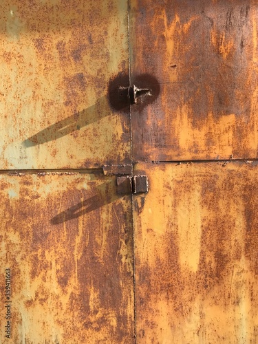 old garage gate made of metal with rust and seams from welding © Egor