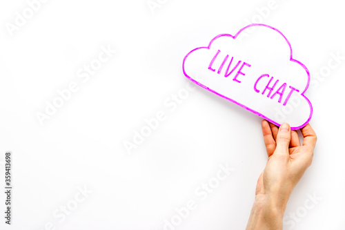 Live chat concept - bubble in hand on white desk top view