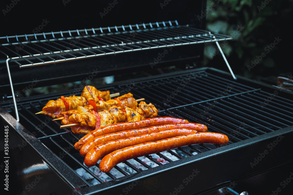 Meat skewers and sausages being grilled on a barbecue