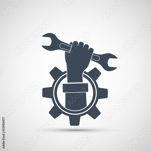 Industrial tool wrench in a human hand. Gear icon.