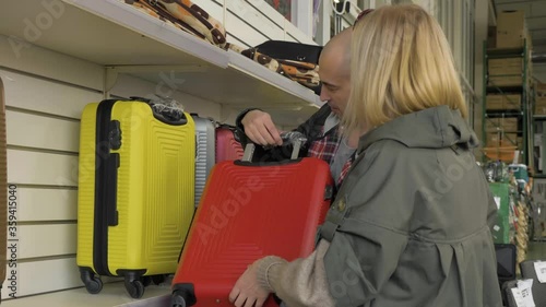 chooses a suitcase in a supermarket