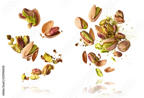 A set with Flying in air fresh raw whole and cracked pistachios  isolated on white background. Concept of Pistachios is torn to pieces close-up. High resolution image photo