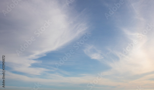 Whispy clouds on a sunny blue sky background.