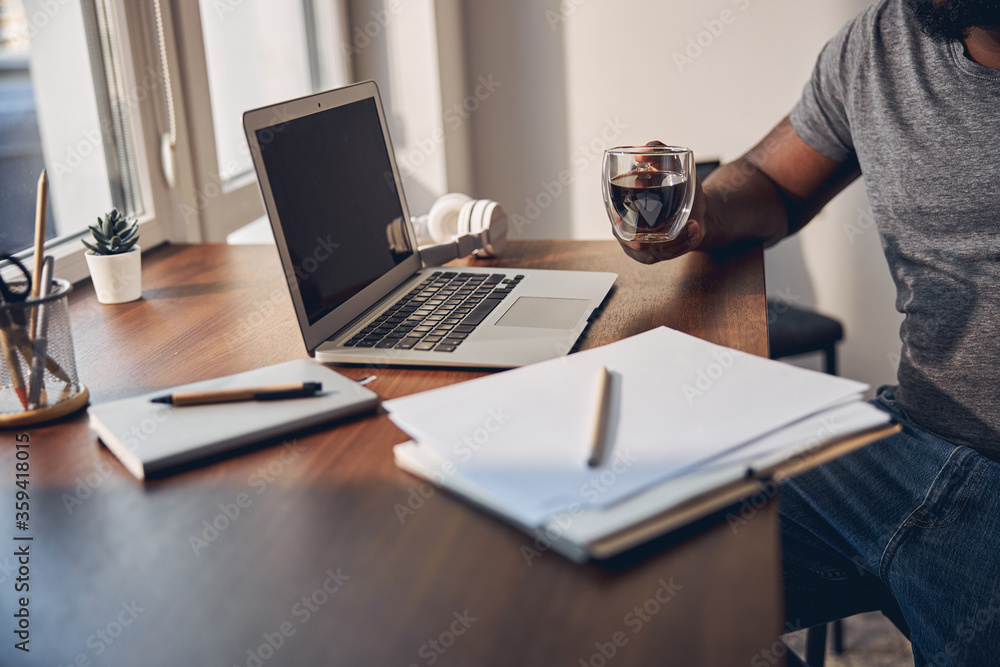 Focused photo on male hand that holding glass cup Focused photo on male hand that holding glass cup