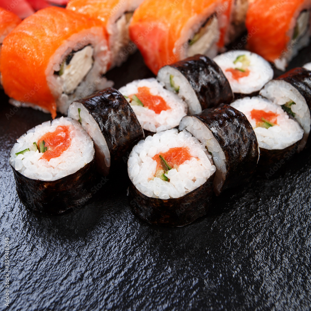 Various kinds of sushi served on stone background. Various kinds of sushi served on stone background.